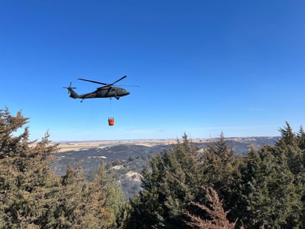 A helicopter drops water in the forest