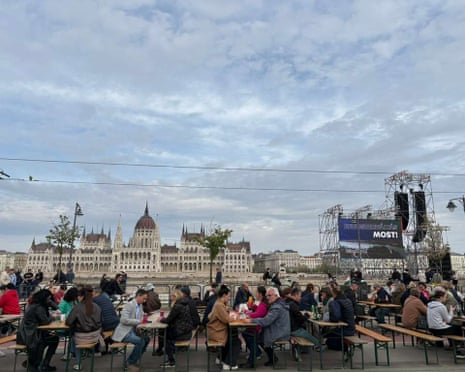 Opposition Tisza party supporters sat opposite the Hungarian parliament as they wait for the polls to close