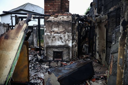 The inside of a burnt-out living room, the roof having collapsed