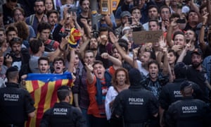 Catalan officers stand in front of protesters as they gesture at Spanish police a day after the referendum.