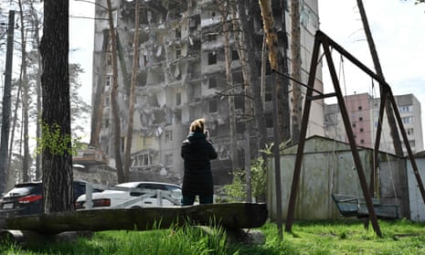 A local resident looks at a heavily damaged residential building in the town of Irpin, Ukraine.