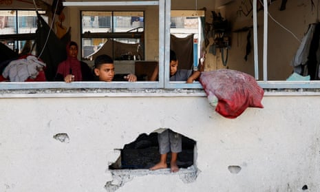 Aftermath of an air strike at a neighbouring house to a UNRWA school, in Khan YounisPalestinian boys stand near the damaged windows of a classroom in a UNRWA school, in the southern Gaza Strip, June 21, 2024. REUTERS/Mohammed Salem