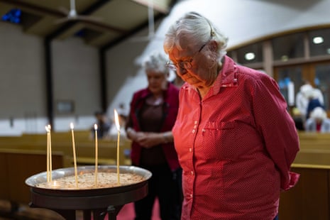 Elderly woman standing with candles