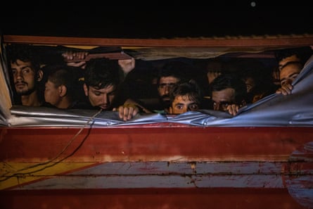 Afghans on a smuggler’s truck after it was seized by officers during a roadside raid in Van, Turkey, 2021.