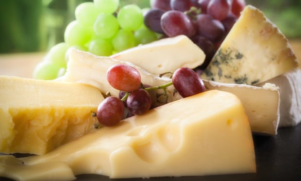 A selection of cheeses arranged on a slate cheese board.