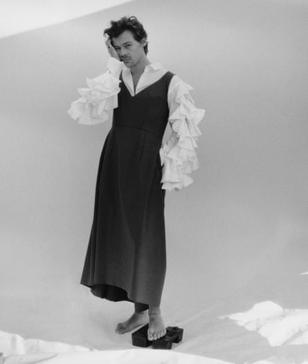Harry Styles wearing a pinafore dress and shirt with ruffled sleeves by Comme des Garçons