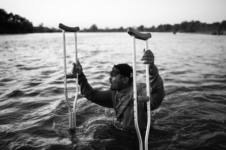 Having travelled across two countries in eight days, Joel, a Honduran with one leg, makes his way across the river with crutches, trying to keep up with the caravan