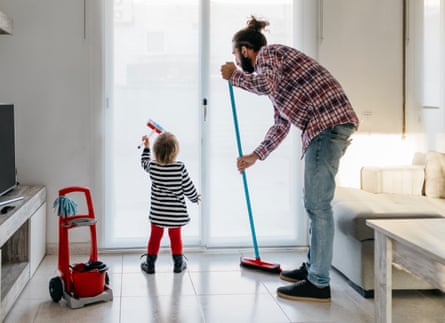Father and little daughter cleaning the living room together