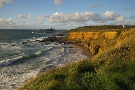 Cliff top and waves and distant lighthouse