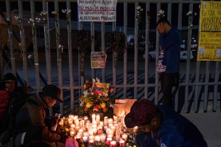 Los migrantes encienden velas durante una vigilia frente a las instalaciones de inmigración en Ciudad Juárez.
