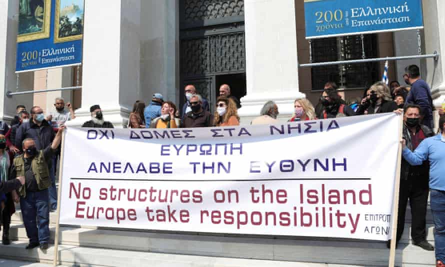 Οι διαδηλωτές κρατούν πανό στο δημαρχείο της Λέσβου κατά την επίσκεψη της Επιτρόπου Εσωτερικών της Ευρωπαϊκής Ένωσης Έλβα Γιόχανσον στη Λέσβο στις 29 Μαρτίου.