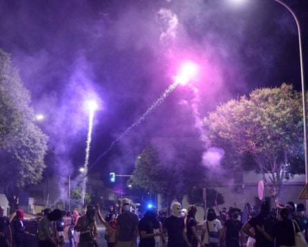People gather on a street as fireworks streak through the night sky, amid anti-immigrant unrest in Torre Pacheco in July.