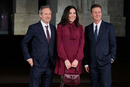 Spike Jonze and actor Edward Norton in dark grey suits pose for photos either side of director Halina Reijn wearing a burgundy dress
