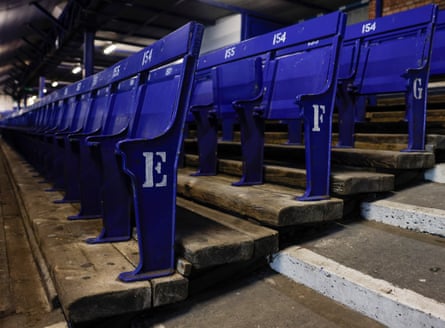 Empty seats screwed into wooden planks balanced on the old concrete terracing in the lower Bullens Road Stand .