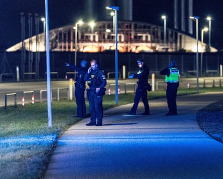 Danish police officers scour and area after Copenhagen airport was closed due to drone reports.