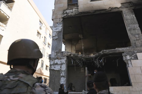 A soldier looks up at the damaged building.