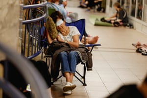 People sleeping in camp chairs inside a metro station