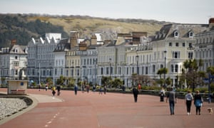 Dog walkers and cyclists on the promenade in Llandudno, north Wales