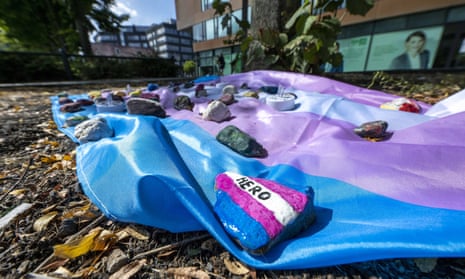 A transgender flag weighed down with painted stones in Münster, Germany, laid in memory of Malte C.