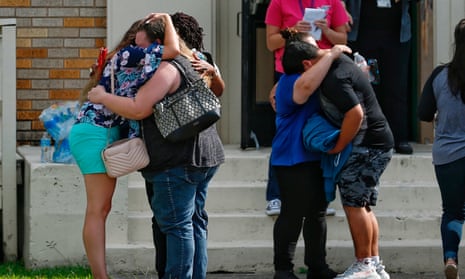 People embrace outside the Alamo Gym where students and parents wait to reunite following a shooting at Santa Fe high school Friday.