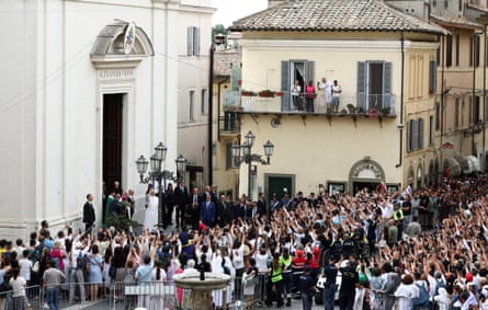 Pope Leo waves to crowds of people outside a church