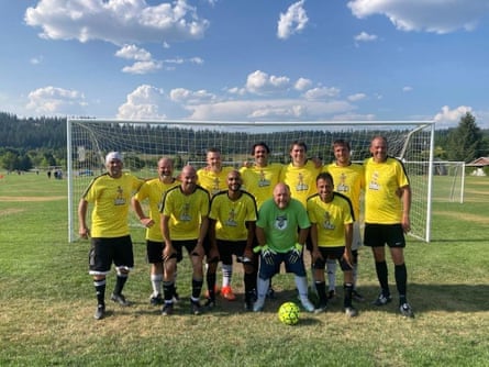 a group of men wearing yellow uniforms stand on soccer field