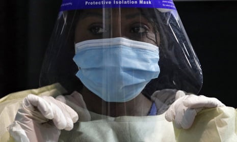 Damaris Kiptoo, a registered nurse, dons personal protective equipment in Las Vegas.