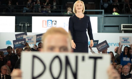 Un manifestant tient une pancarte alors que Liz Truss arrive sur scène lors d'un événement de hustings à Wembley Arena, Londres, dans le cadre de la campagne pour être le chef du Parti conservateur et le prochain Premier ministre.