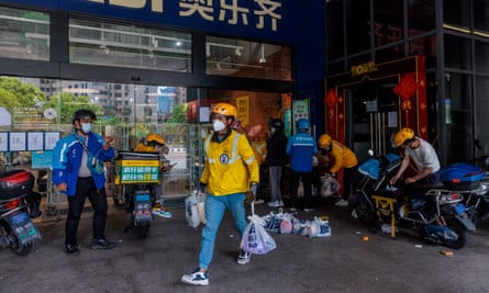 Delivery drivers sort food at a supermarket in Shanghai, 25 April 2022.