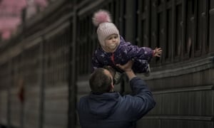A man plays with a child before she boards a Lviv bound train, in Kyiv, Ukraine.
