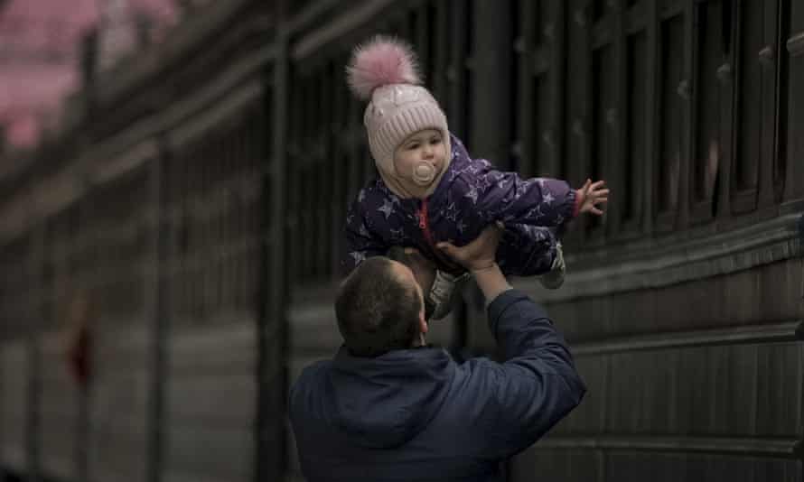 A man plays with a child before she boards a Lviv bound train, in Kyiv, Ukraine on 12 March.