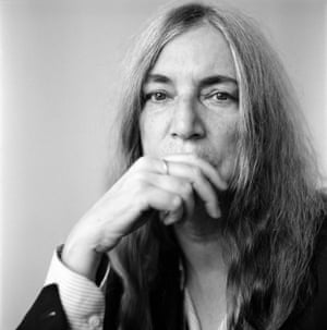 Patti Smith looking uncompromisingly into the camera, hand over her mouth.