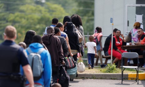 A group of asylum seekers wait to be processed in Lacolle, Quebec, Canada on 11 August 2017.