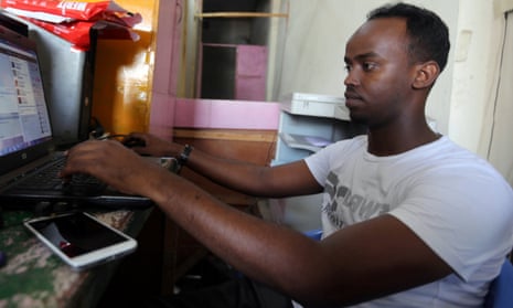 Abdifutah Ahmed Hassan browses the internet at the cyber cafe he manages in Mogadishu, Somalia.