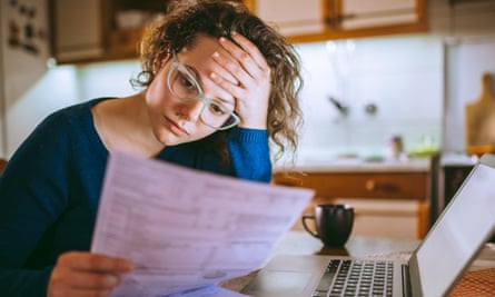 A woman with a laptop going through bills, and looking worried