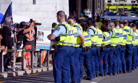Police conduct an operation to constrain protesters outside the parliament grounds in Wellington on February 22, 2022, as anti-vaccine demonstrators occupy the streets and grounds outside.