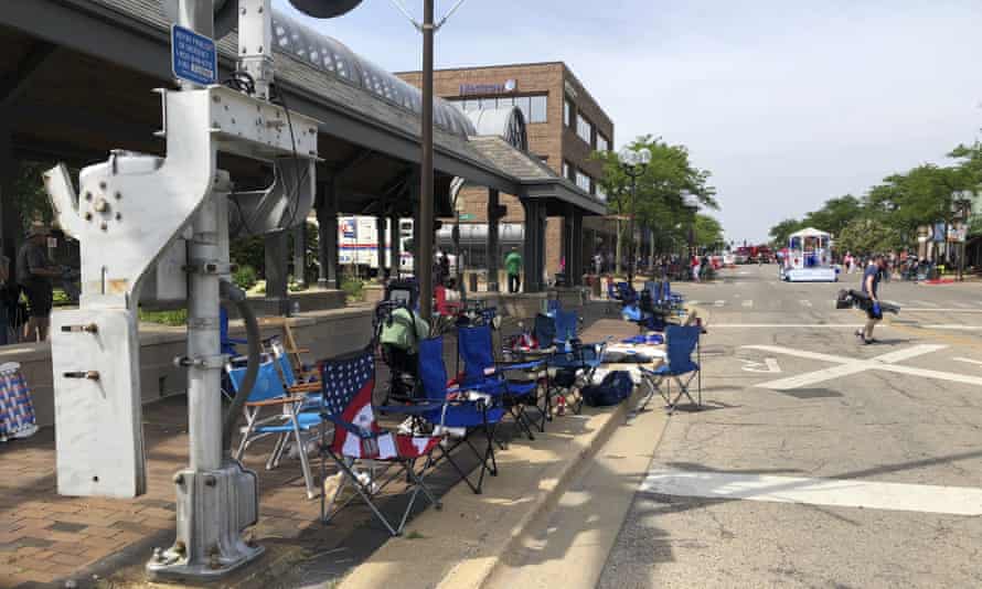 Empty chairs sit along the sidewalk after parade-goers fled Highland Park’s Fourth of July parade after shots were fired, Monday, July 4, 2022 in Highland Park, Ill. (Lynn Sweet/Chicago Sun-Times via AP)