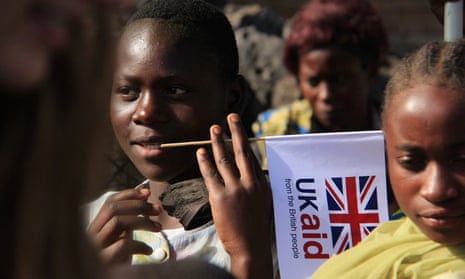 A child in the Democratic Republic of the Congo is seen holding a UK aid flag