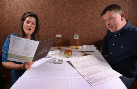 Nyree and Karl choosing from the menu at a restaurant table