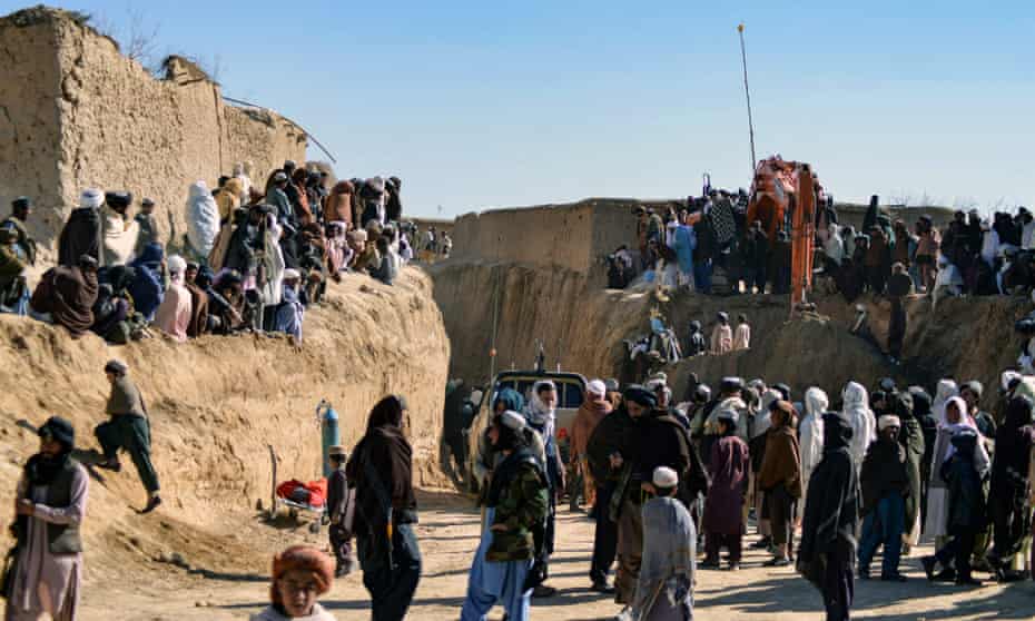 People gather as rescuers try to reach a boy trapped for two days down a well in a remote southern Afghan village of Shokak.