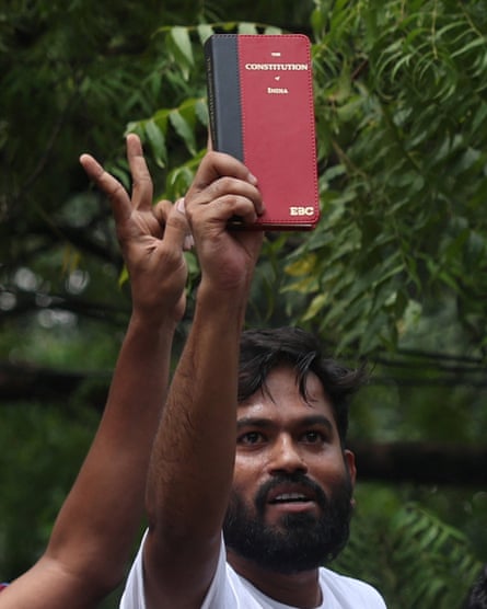 Abhijeet Dipke holds aloft a copy of the constitution of India