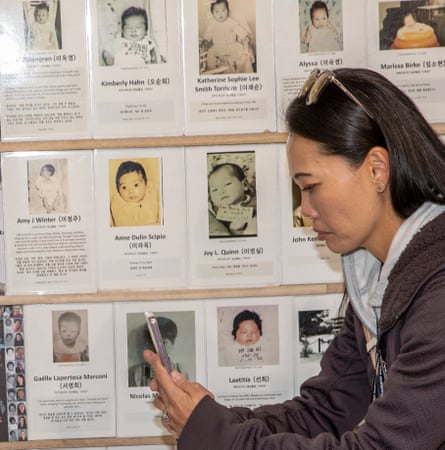 A woman takes pictures of missing children posters