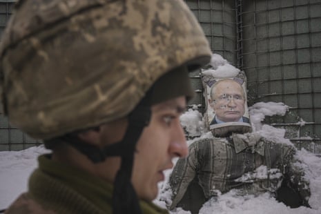 A Ukrainian serviceman speaks, backdropped by a bullet riddled effigy of Russian President Vladimir Putin, during a media interview at a frontline position in the Luhansk region, eastern Ukraine.