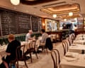 Chez Rose, London: 'showstopping cuisine'. Diners sit at white-clothed tables in a restaurant with green banquettes, chalkboard menus, and decorative ceiling panels