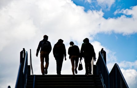 Silhouette of students crossing a bridge