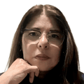 Unsmiling woman with long brown hair parted in the middle, and glasses