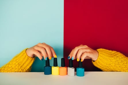 Aesthetic shot of hands with painted nails reaching for brightly-painted bottles