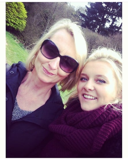 Selfie-style photo of woman with sunglasses next to younger woman outdoors in garden