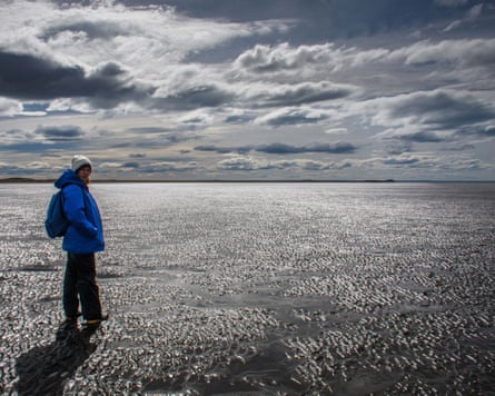 A woman stands on what appears to be a beach
