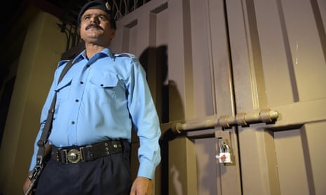 A Pakistani policeman stands guard outside the office of the international charity ‘Save the Children’ sealed by order of Pakistani authorities in Islamabad.
